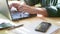 Close-up of male hands using laptop at cafe, man`s hands typing on laptop keyboard in interior, side view of freelancer