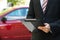 Close-up of male holding clipboard near car