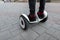 Close-up of male legs in black stylish jeans in trendy sneakers in red socks on a gyroscope. Fashionable guy rides