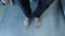 Close up of male legs in jeans stands up from toilet. Man with bare feet stand up from white toilet in bathroom with grey tiles on