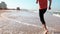 Close-up male legs run along seashore summer beach. Freedom concept. Low angle side view. Man enjoying vacations. 4K