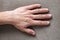 Close-up of male masculine worker hand with rough skin and short fingernails resting on flat copy space background, top view.