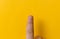Close up Male one finger with bitten, gwaned, chewed or ugly nails, a Bit bad nail and isolated on a yellow background