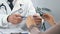 Close up of male ophthalmologist choosing eyeglasses for patient, checkup