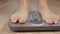 Close up male or woman foot stepping on weight scale for weighting body