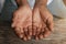 Close up of male wrinkled hands, old man is wearing on the wood table