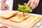 Close up of man adding lettuce leaves to sandwich