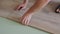 Close-up of a man in an apartment laying laminate on the floor.