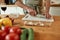 Close up of man in apron peeling, cutting garlic while preparing dinner, standing in the kitchen. Cooking at home