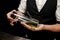 Close-up. Man bartender holds special designer glass flask with canabis cocktail inside