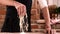 Close-up of man in black apron pours flour in kitchen. Baker sprinkles pinch of flour on baking