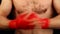 Close up man boxer tightens wrists with red wrap