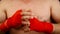 Close up man boxer tightens wrists with red wrap