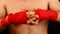 Close up man boxer tightens wrists with red wrap