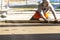 Close up of man builder placing screed rail on the floor covered with sand-cement mix at construction site. Male worker leveling