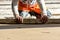 Close up of man builder placing screed rail on the floor covered with sand-cement mix at construction site. Male worker leveling