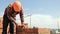 Close up of a man building a brick house. Laying red bricks on a construction site on a sunny day. House construction