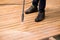 Close up of a man cleaning terrace with a power washer - high water pressure cleaner on wooden terrace surface