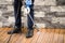 Close up of a man cleaning terrace with a power washer - high water pressure cleaner on wooden terrace surface