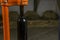 close-up of a man corking a bottle of wine at a winery .