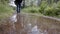 Close-up of man crossing puddle. Stock footage. Close-up of puddle with reflection of traveler crossing it on background