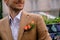 Close-up man dressed in classy jaket with three roses in poket