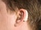 Close-up of a man ear with a hearing aid