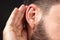 Close-up of man ear with palm listening and collecting rumors. Concept of secret or sense organs, hearing.