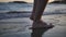 Close up of man feet leaving marks on the sand on the sea, travel concept