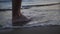 Close up of man feet leaving marks on the sand on the sea, travel concept
