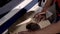 Close-up of man grinds wood products on industrial machine. Action. Carpenter polishes wooden product for tape