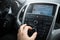 Close-up of man hand adjusts the volume control of car audio system