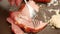 Close up of man hand with chrome long and sharp knife cutting roast pork ham