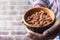 Close up of man hand holding a bowl of almond with copy space