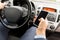 Close up of man hand with smartphone driving car