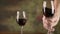 Close up man hand stirring red wine in glass before tasting slow motion