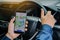 Close-up Of Man Hand Using GPS Navigation Inside Car by application on smartphone