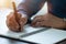 Close-up of man hand using writing pen memo on notebook paper