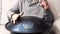 Close up of man hands playing hang drum indoors. Unusual music instrument