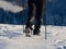 Close up of a man hiking on a mountain covered on snow, in boots with shoe skpikes. Outdoor winter trekking