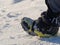 Close up of a man hiking on a mountain covered on snow, in boots with shoe skpikes. Outdoor winter trekking