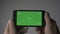 Close Up Man Holding Smartphone Touch With Green Screen Chroma Key in horizontal position
