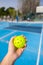 Close-up of a man holding yellow pickleball ball