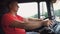 Close up of man holds arms on steering wheel and controls truck riding to destination. Lorry driver operating a car