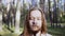 Close-up of a man with long hair and beard. He stands in the middle of the forest with his eyes closed. Moment of concentration.