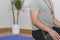 Close up of man meditating on the lotus position inside his house on a mat with a Buddhist necklace mala