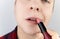 Close-up of a man painting his lips. The concept of protecting the rights of the LGBT community, a clear manifestation of
