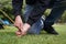 Close up of a man pegging down a tent on grass.