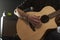 Close Up Of Man Playing Amplified Acoustic Guitar