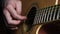 Close-up of man playing guitar. Concept. Professional guitar player moves fingers along strings of guitar beautifully